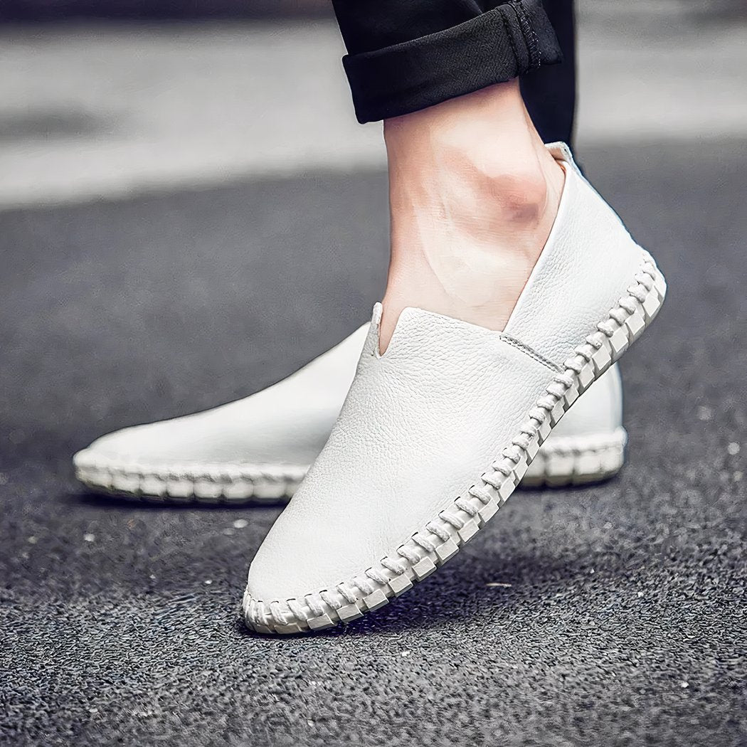 Men's casual white loafers worn on a street Image