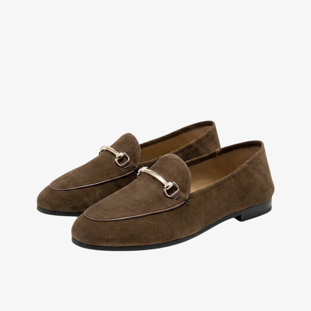 Brown genuine suede loafer with a metal horsebit detail, on a gray background