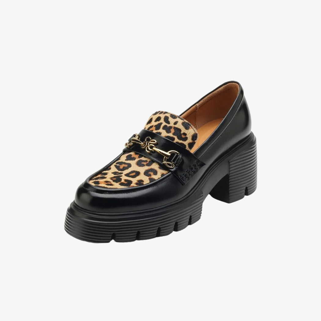 Women's black leather loafers with a leopard print upper for a bold touch. A gold-tone metal buckle adds a sophisticated finish, while the thick notched heels offer both style and stability.