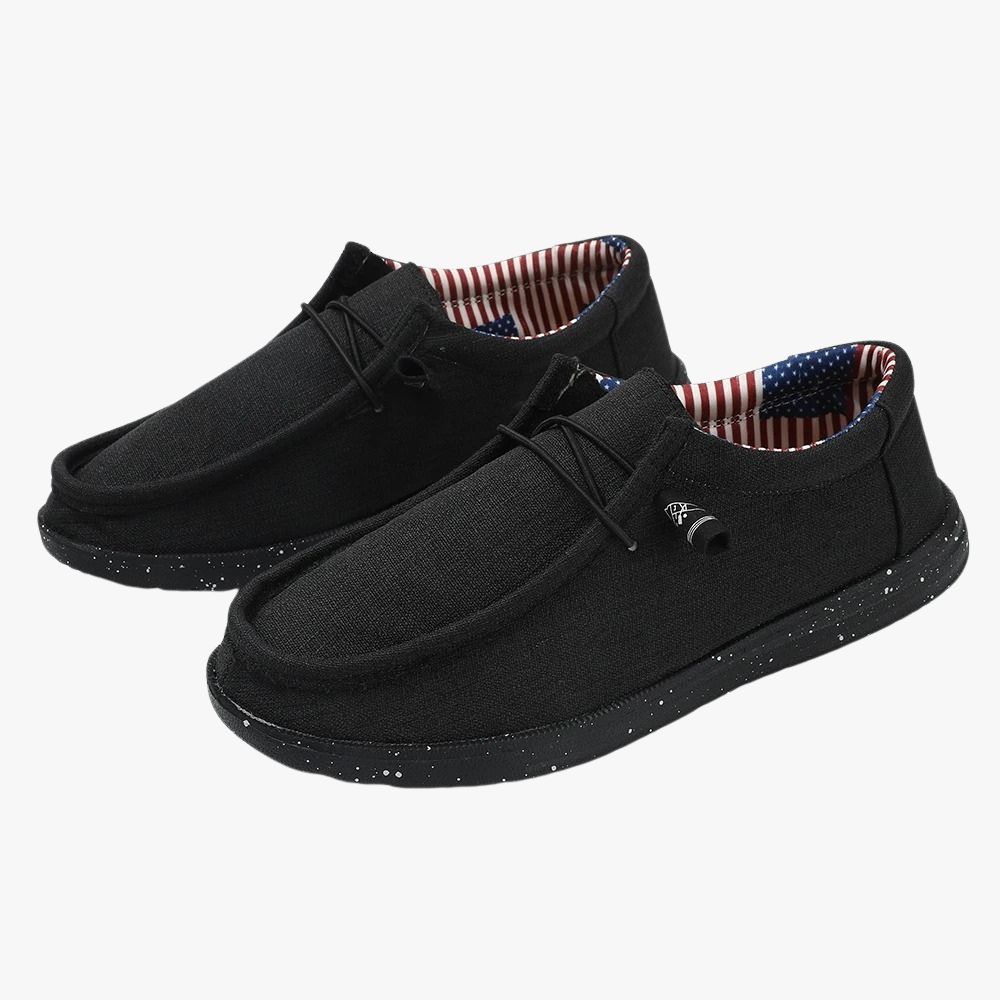 Black fabric loafers with a thick sole. The fabric lining features a pattern of the American flag.