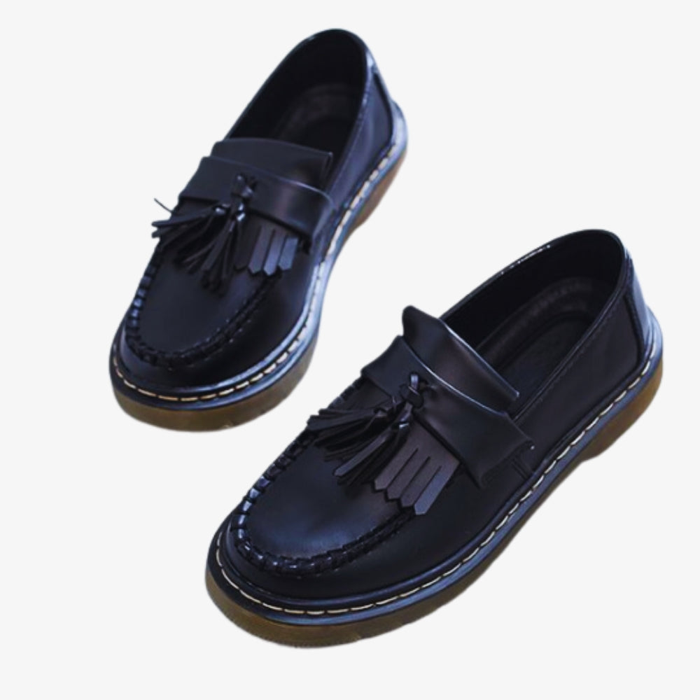 on a white background, a pair of women's synthetic leather tassel and fringe loafers, in black