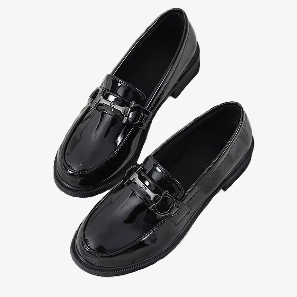 Loafers in patent leather with metallic details on a white background