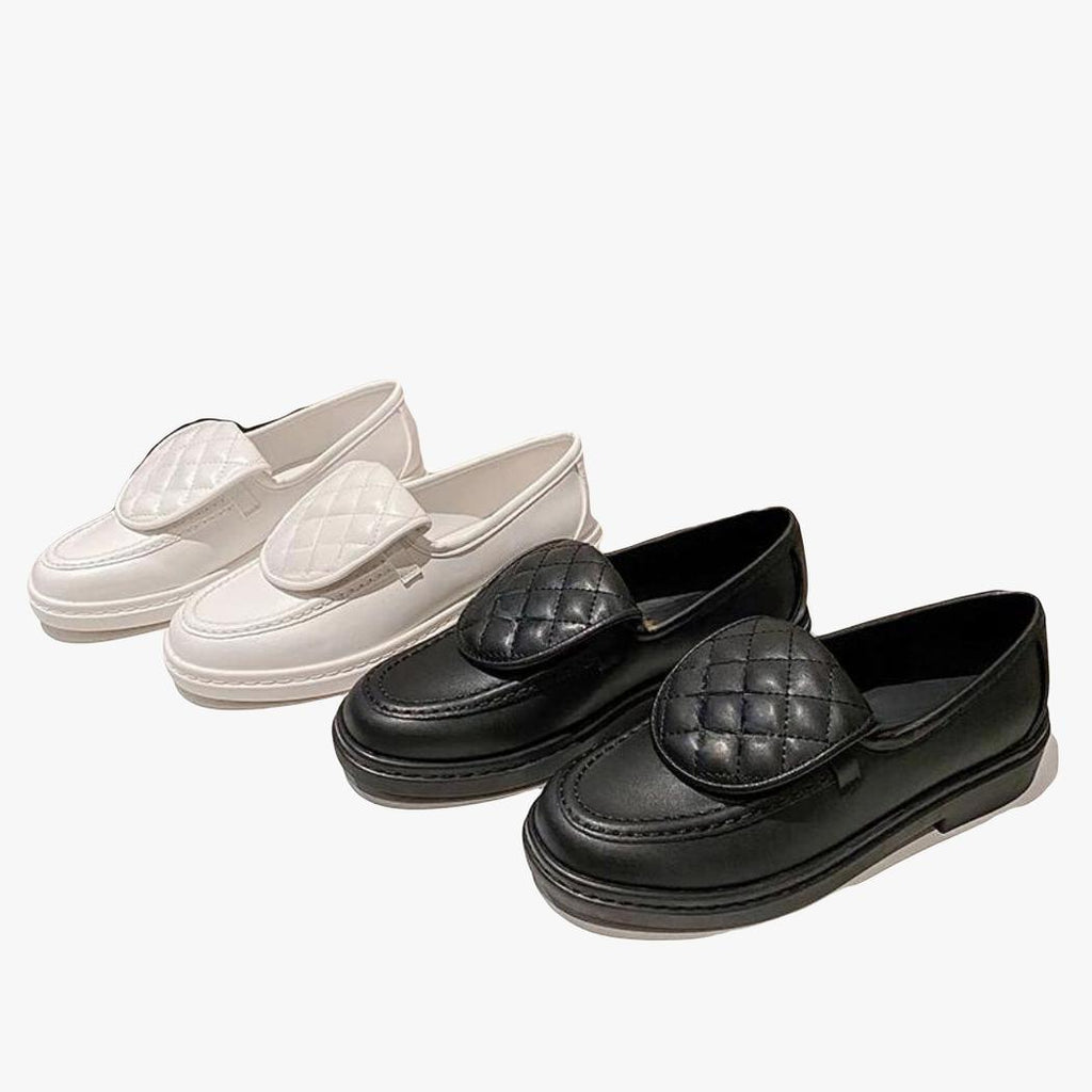 Two pairs of women's quilted square-heel loafers side by side, one white and one black