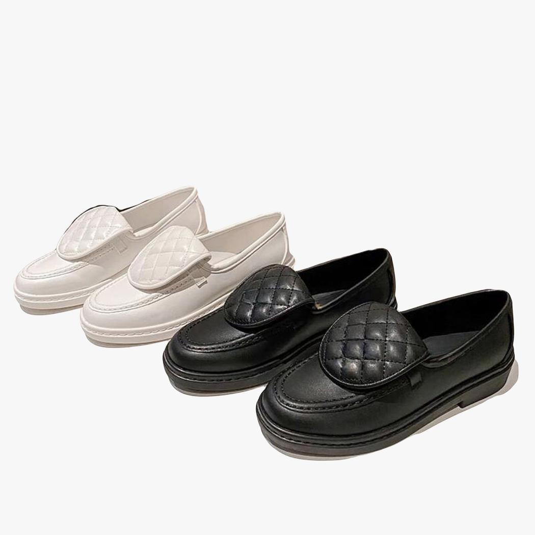 Two pairs of women's quilted square-heel loafers side by side, one white and one black