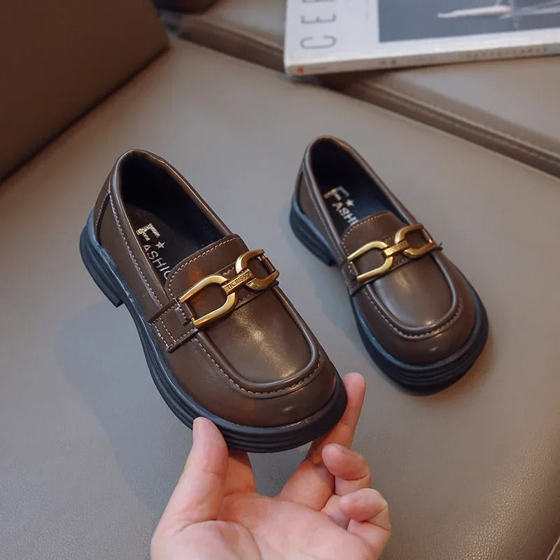 Girls' dark loafers with a polished metal buckle