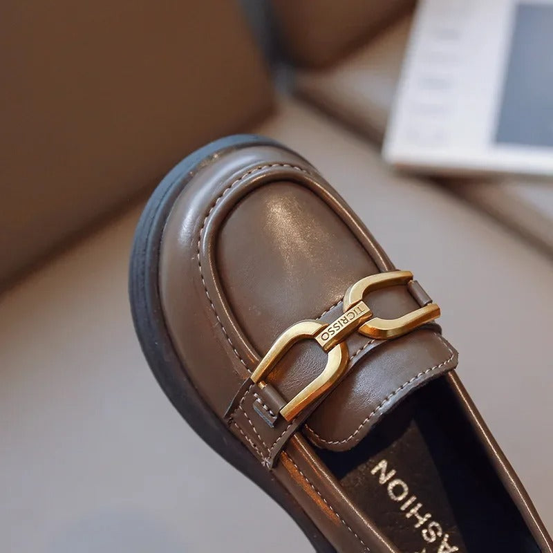 Girls' dark loafers with a polished metal buckle