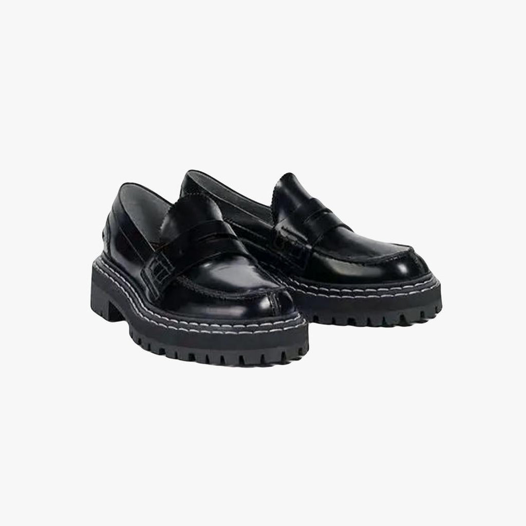 A pair of women's black faux leather loafers with chunky soles on a light grey background
