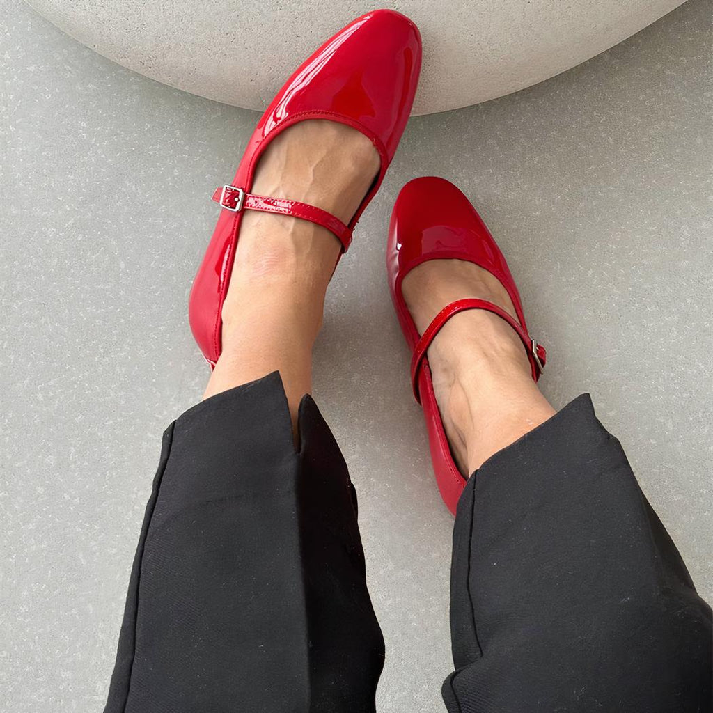 Patent leather loafer flats with a thin buckle strap across the instep