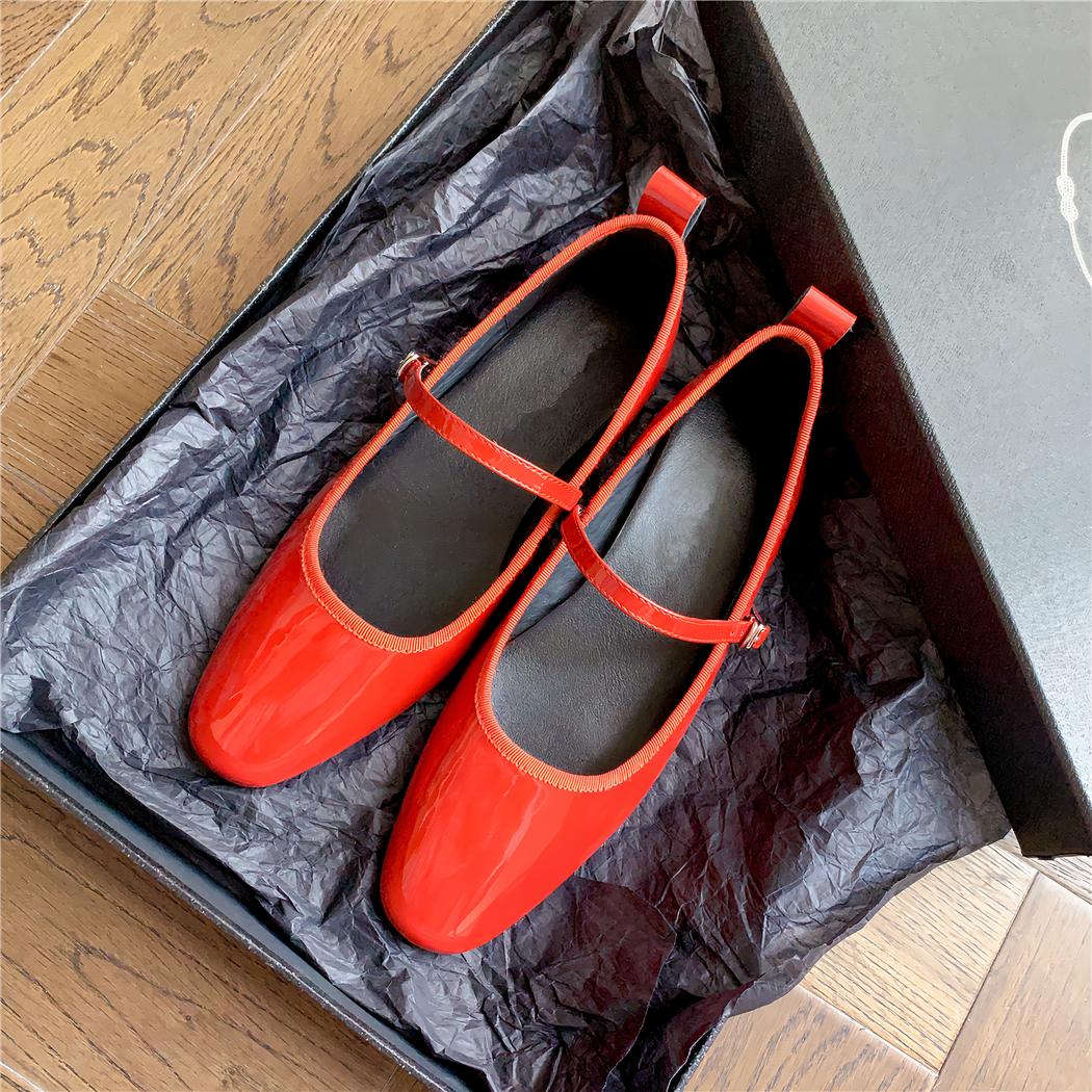 Patent leather loafer flats with a thin buckle strap across the instep
