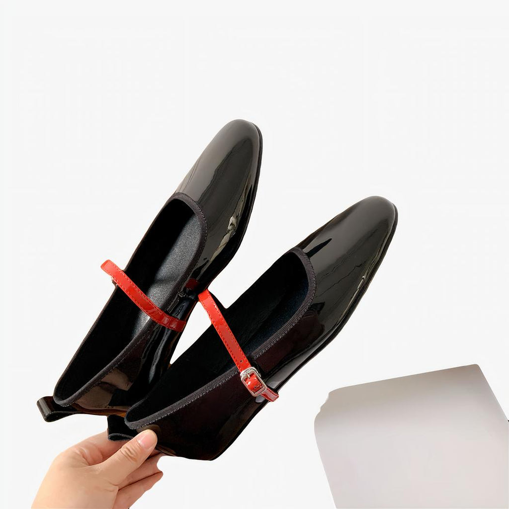 Patent leather loafer flats with a thin buckle strap across the instep