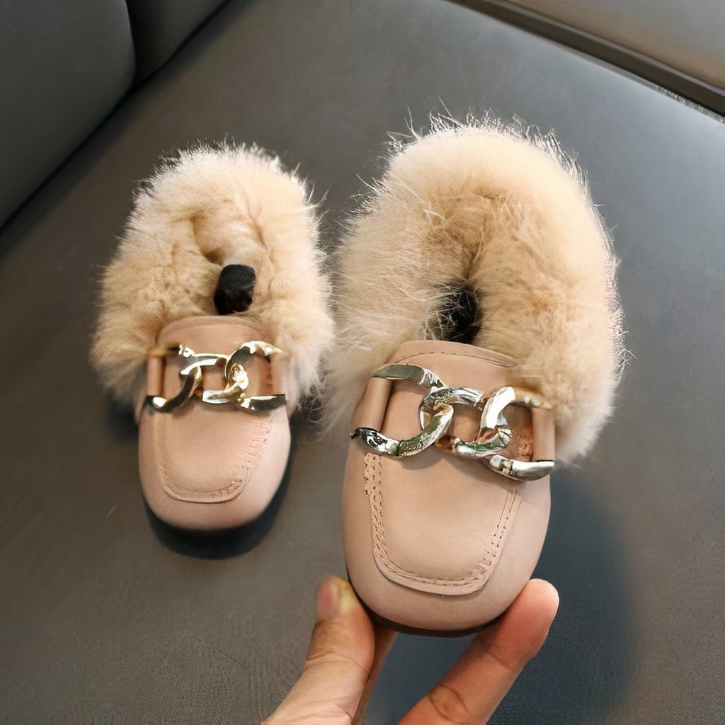 fur loafer with baby rings worn in a woman's hand
