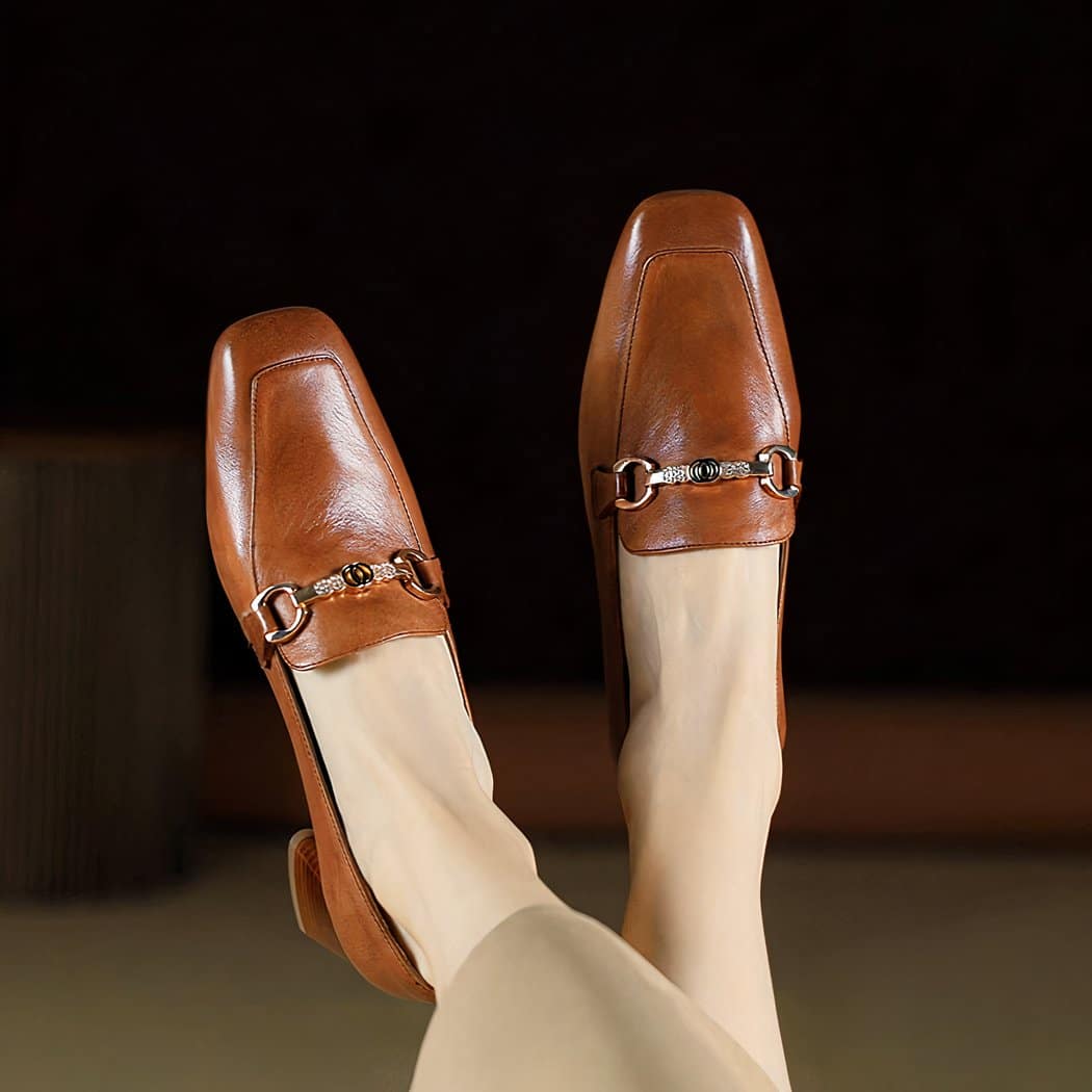 brown leather loafer with a ring at the top worn by a woman