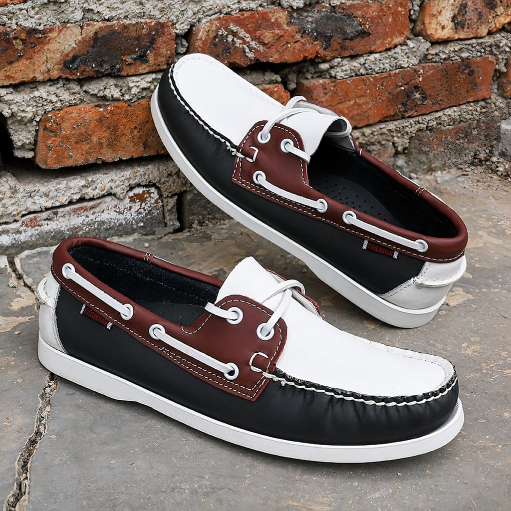 Photo of a pair of white, red and black loafers on a brick wall and gray floor