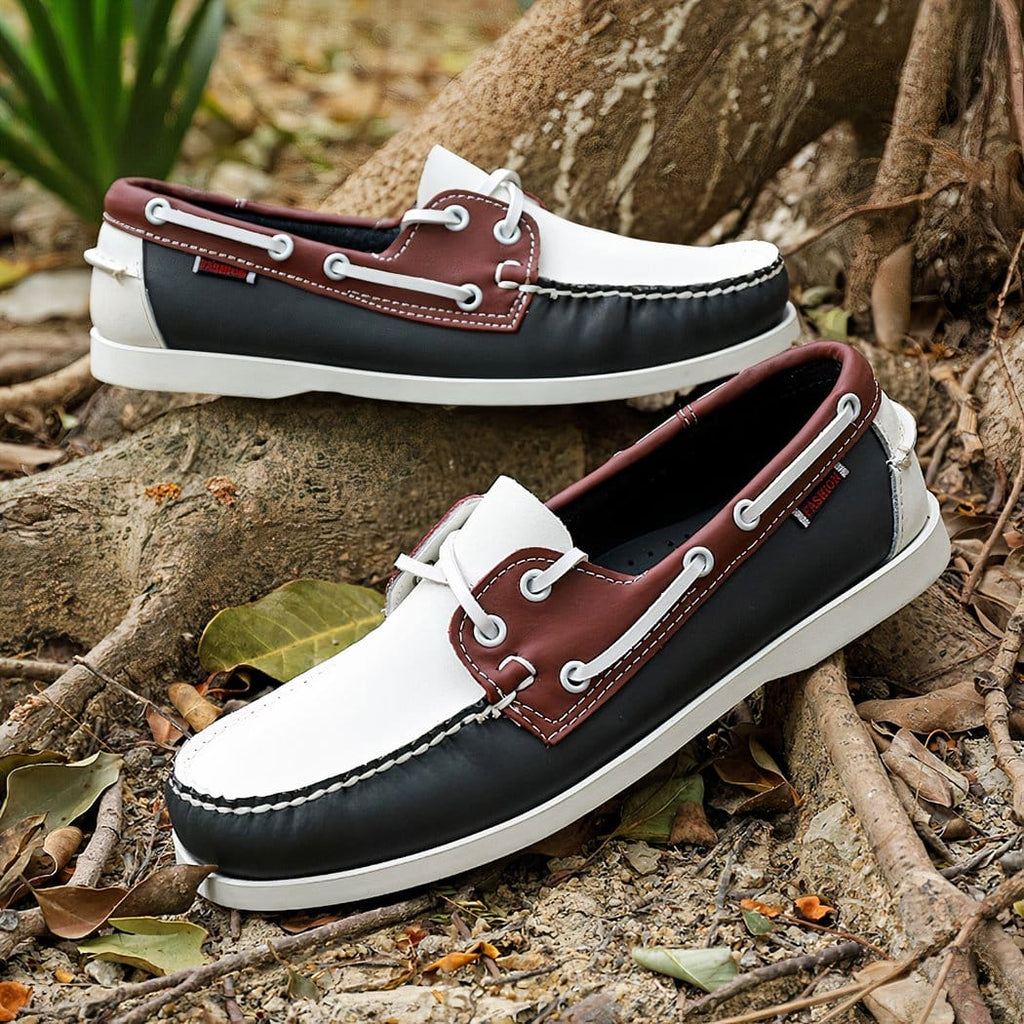 Photo of a pair of tricolor boat loafers at the foot of a tree