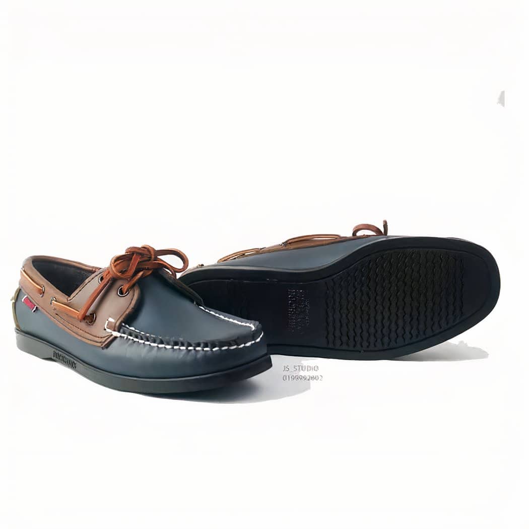 Photo of a pair of navy blue and brown loafers on a white background