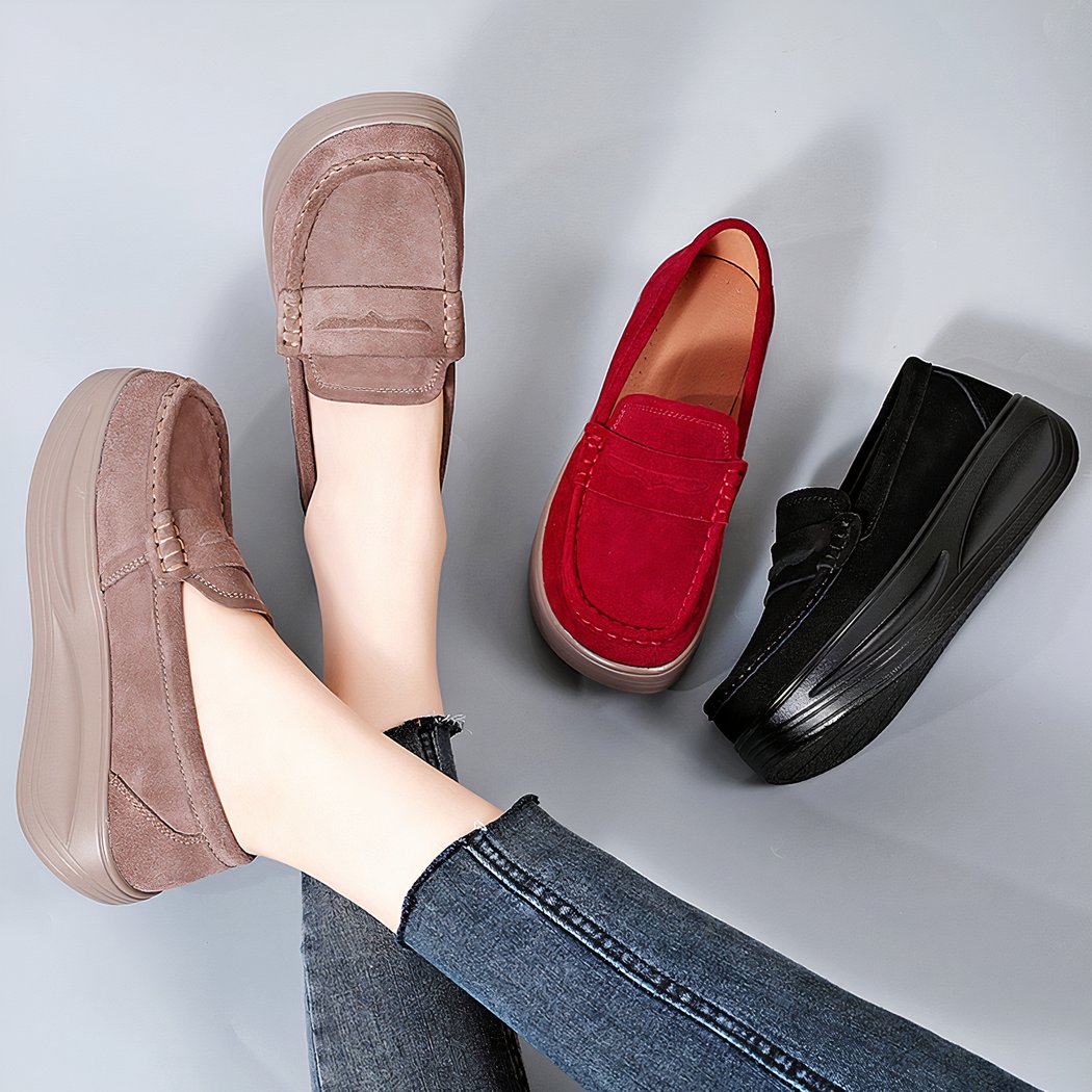 Pair of beige suede orthopedic platform loafers worn with one red and one black loafer next to them