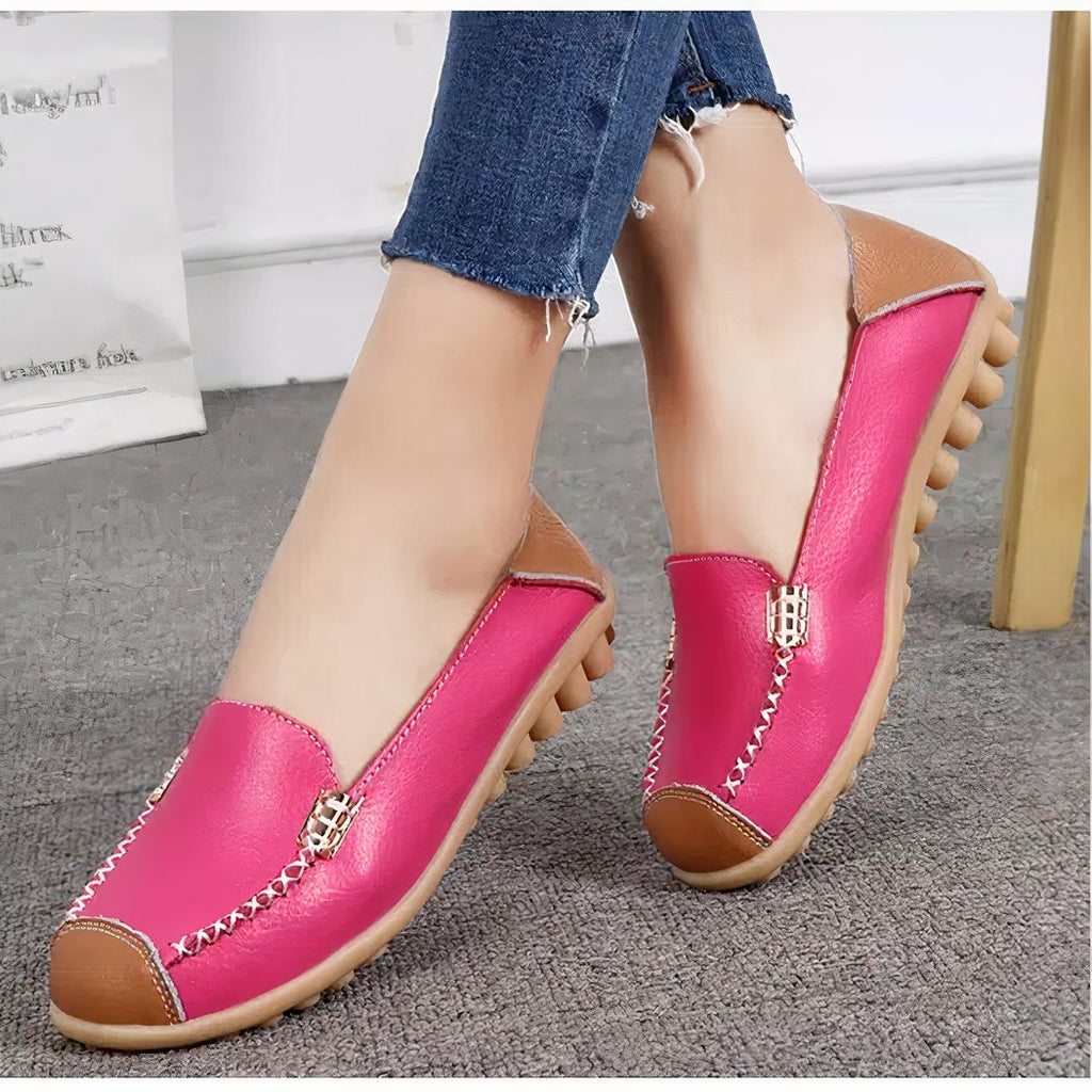 loafer with pink-cut toe, feet on carpet, woman with legs crossed