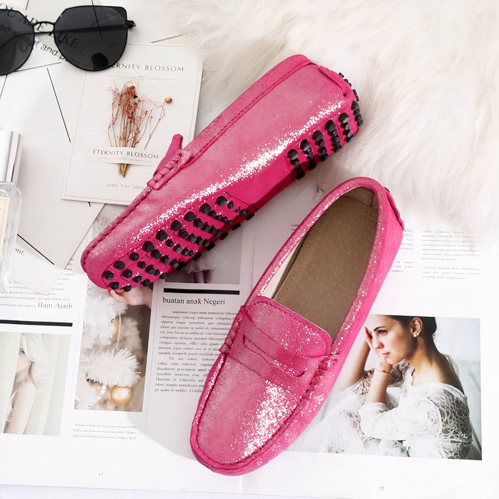 Photo of a pair of pink loafers on newspapers, a pink plaid and sunglasses