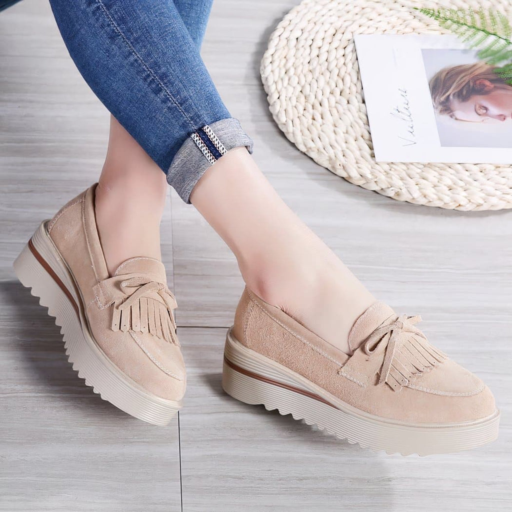 beige tassel wedge loafer worn by a woman