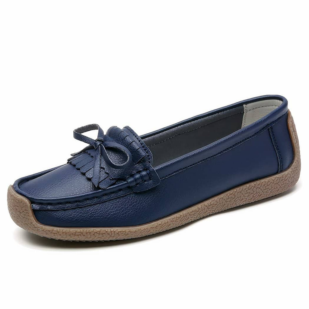 dark blue leather loafer with tassel on top set against a white background