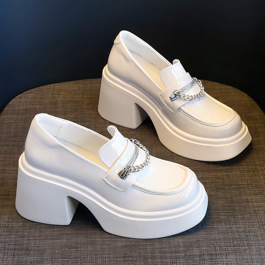 loafer with white compensating heel in patent leather on a brown table