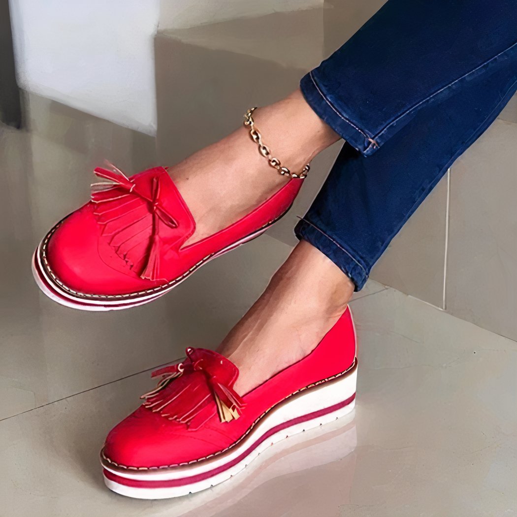 red loafer worn by a woman with an ankle chain