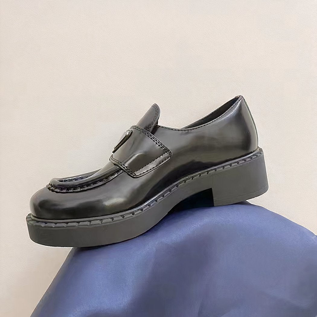 black leather loafer on a blue floor
