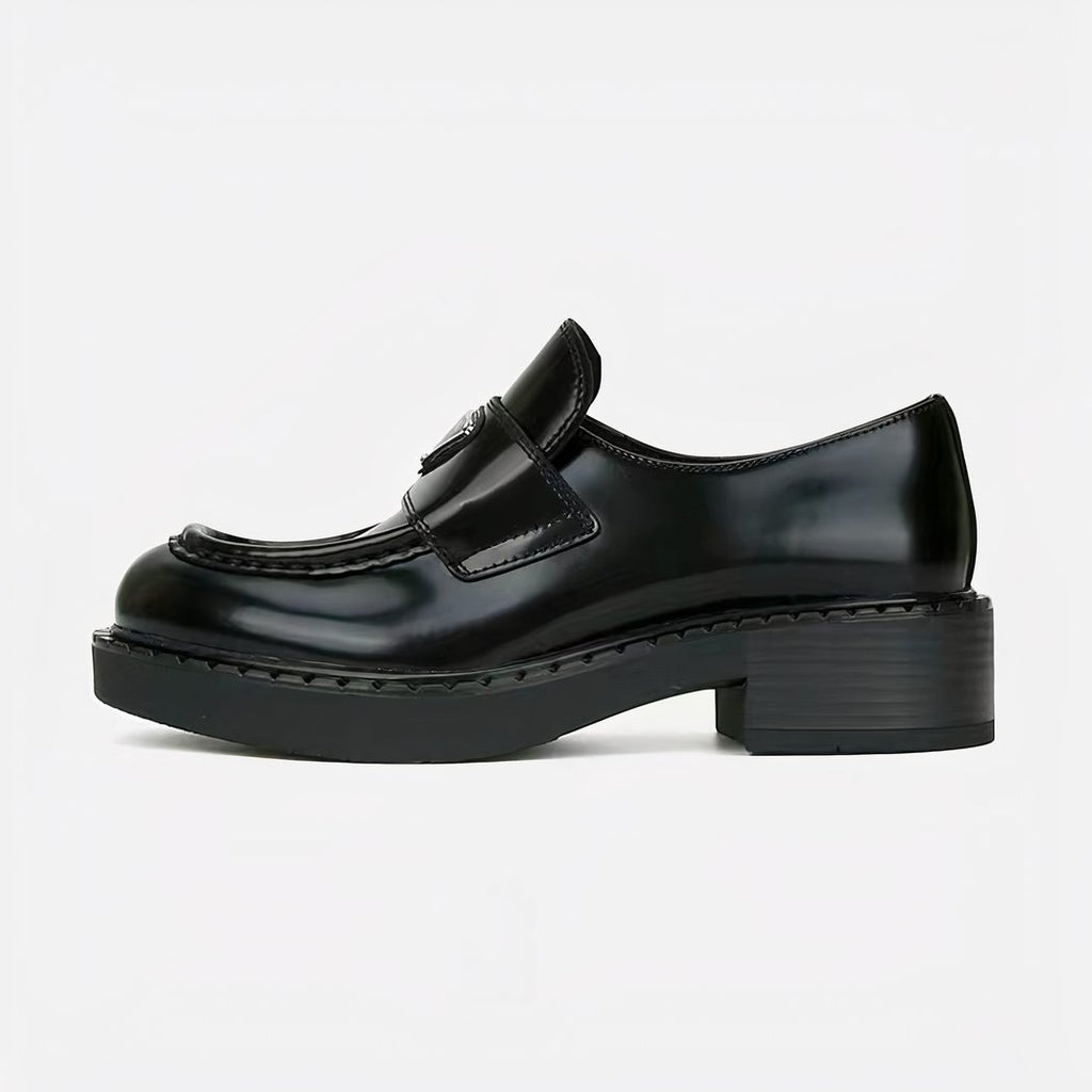 black leather loafer with small heel set on a white background