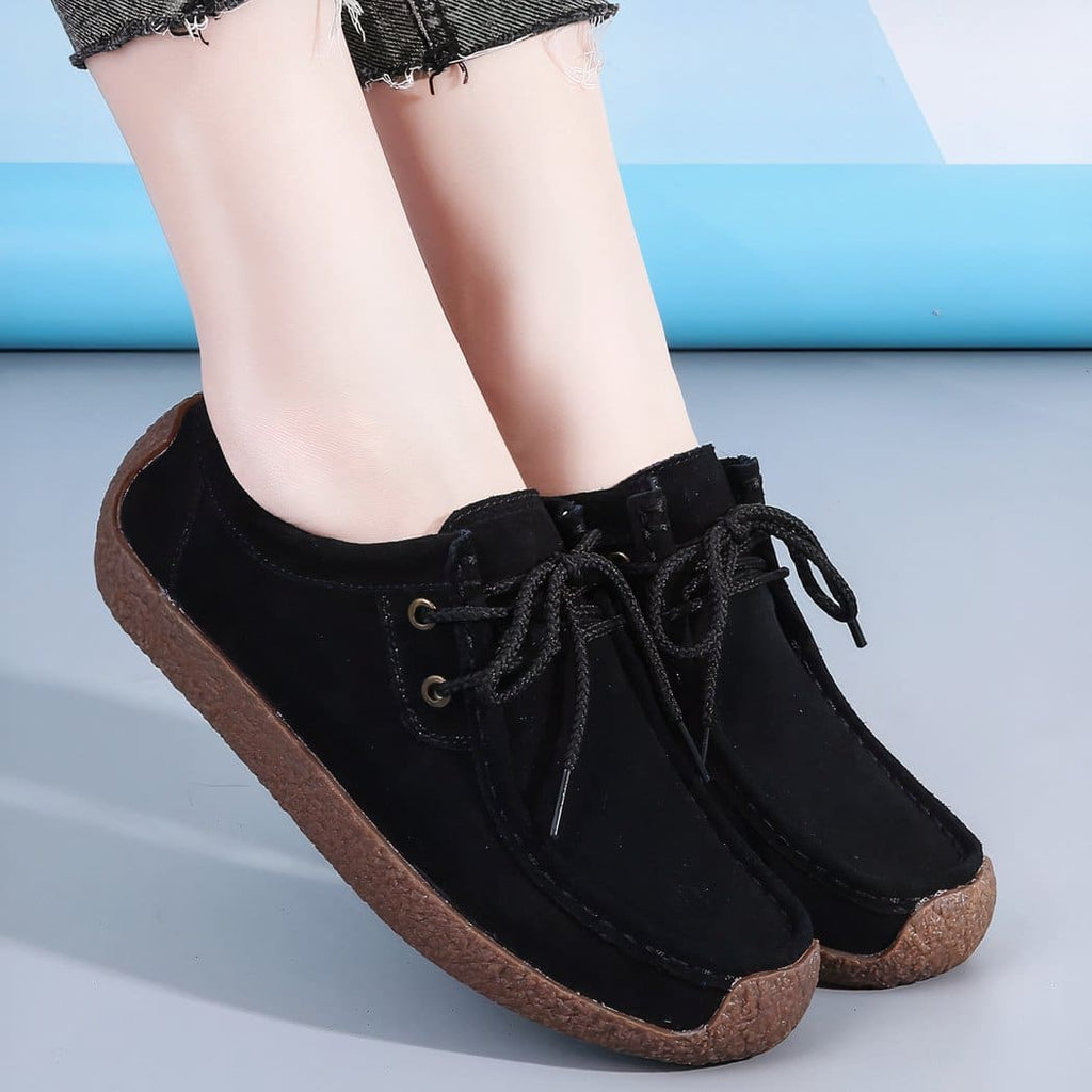 black lace-up loafer worn by a woman