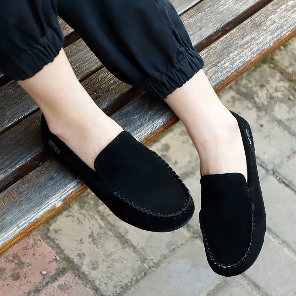 black suede loafer worn by a woman