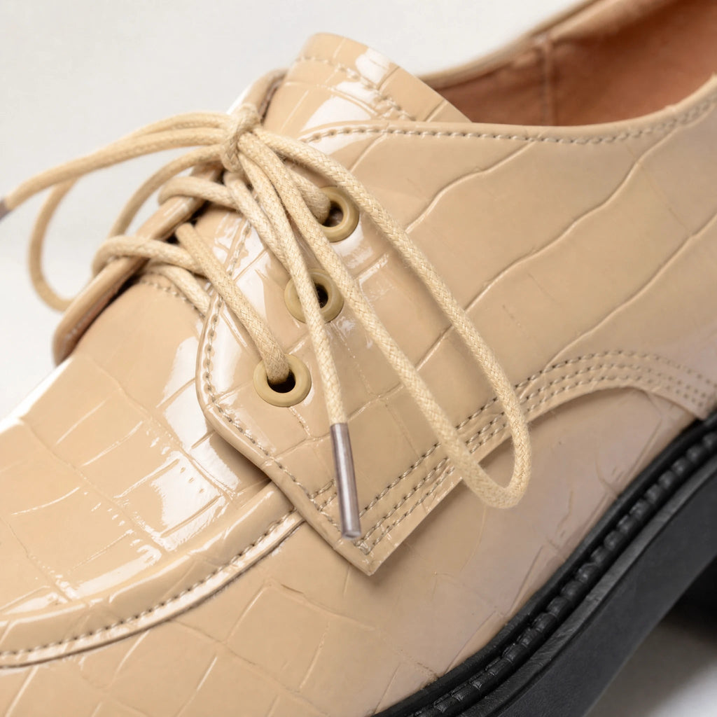 Beige patent croc-effect moccasin with black notched sole