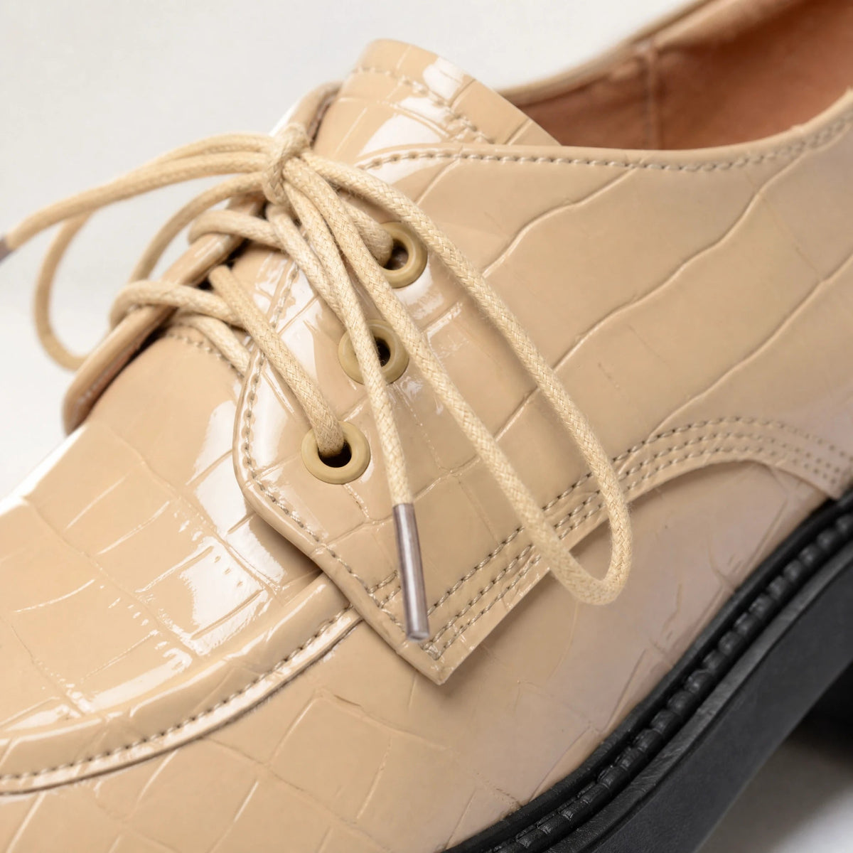 Beige patent croc-effect moccasin with black notched sole Image