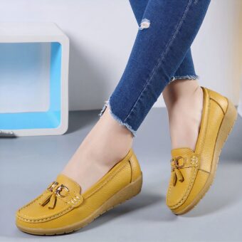 Yellow moccasins worn by a woman whose calves can only be seen.