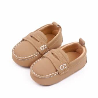 brown baby moccasin in faux leather with exposed white stitching on a white background