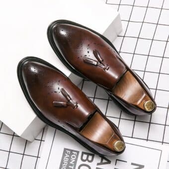 Brown moccasins with tassel set on a white box and checkered floor
