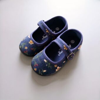 children's blue corduroy moccasin on a grey wall