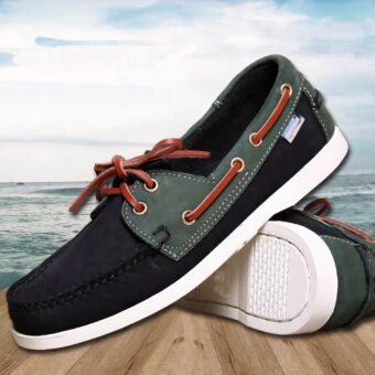 Photo of a pair of black and gray boat moccasins on a parquet floor and marine background with a cloudy blue sky