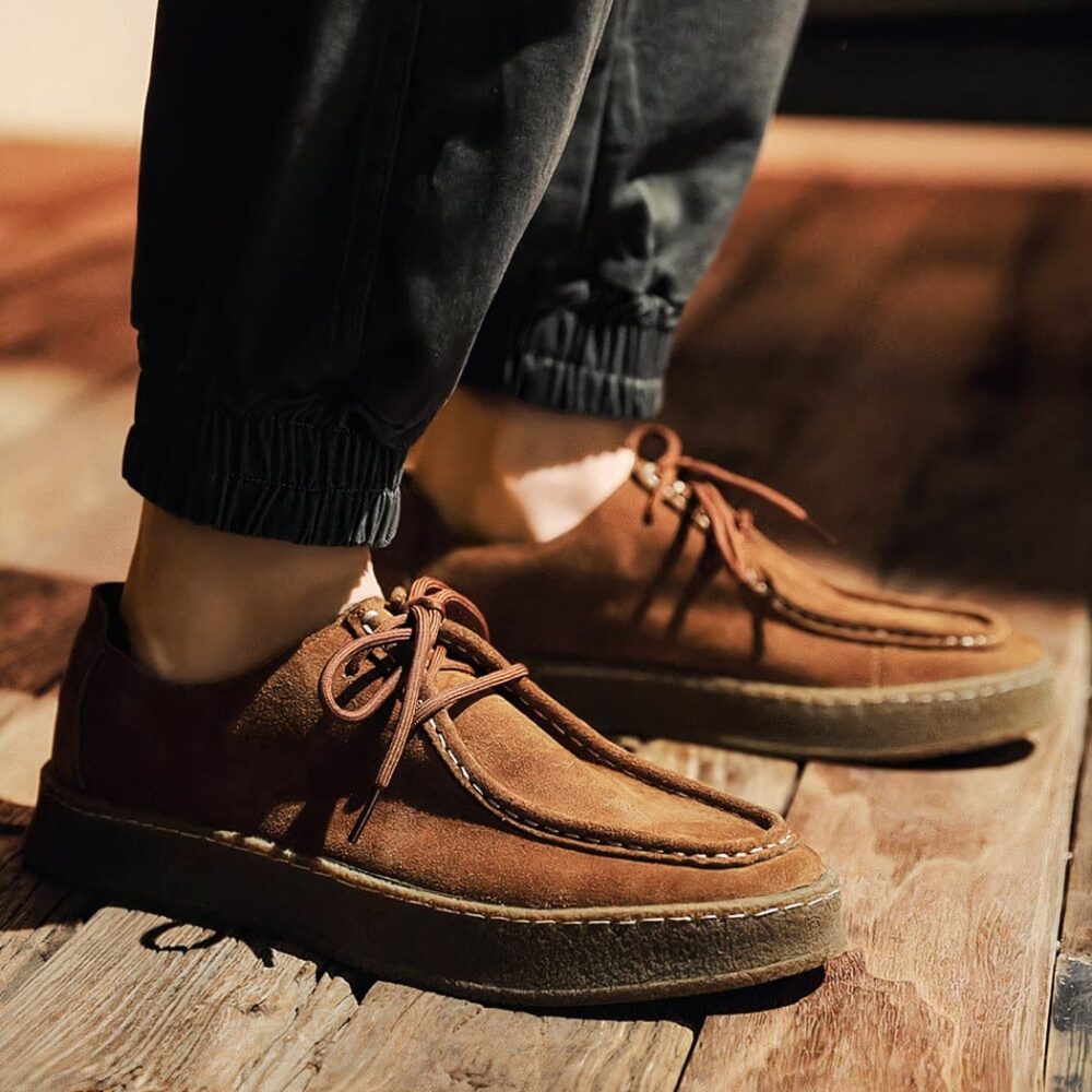 PHoto of a modern Indian-style moccasin in brown suede, worn by a man with jeans