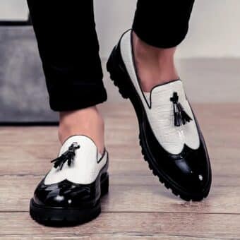 Walking feet in black and white moccasins with a black pompom on top.