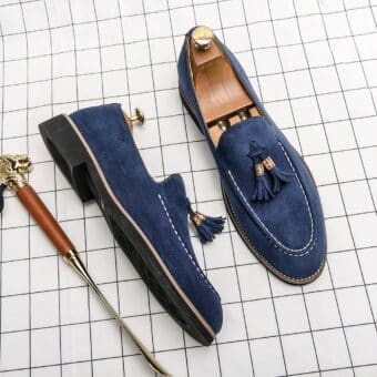 Blue moccasins with side shoe, all set on a white checkered surface.