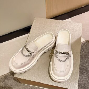 Photo of a pair of white platform loafers on a white box