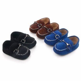 On a white background, 3 pairs of soft black, brown and blue suede moccasins with visible white stitching and a silver bit on top