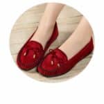 red suede moccasin on women's feet