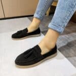 black suede fringe moccasin worn by a woman