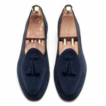 Pair of navy blue suede loafers on a white background