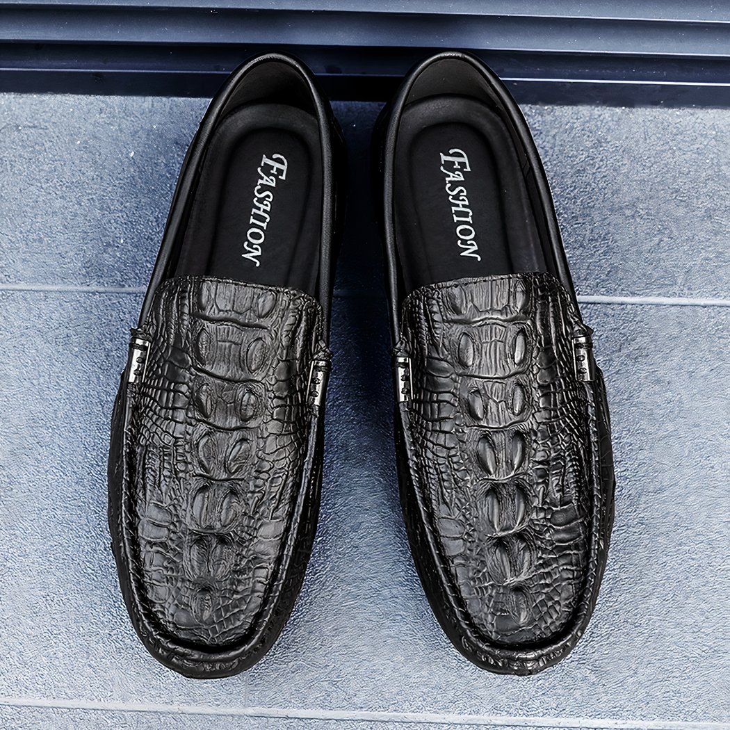 Photo of black crocodile-patterned leather loafers on a grey floor