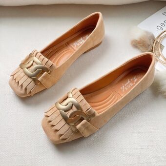 beige suede moccasin with tassel and ring on top to stand on a table