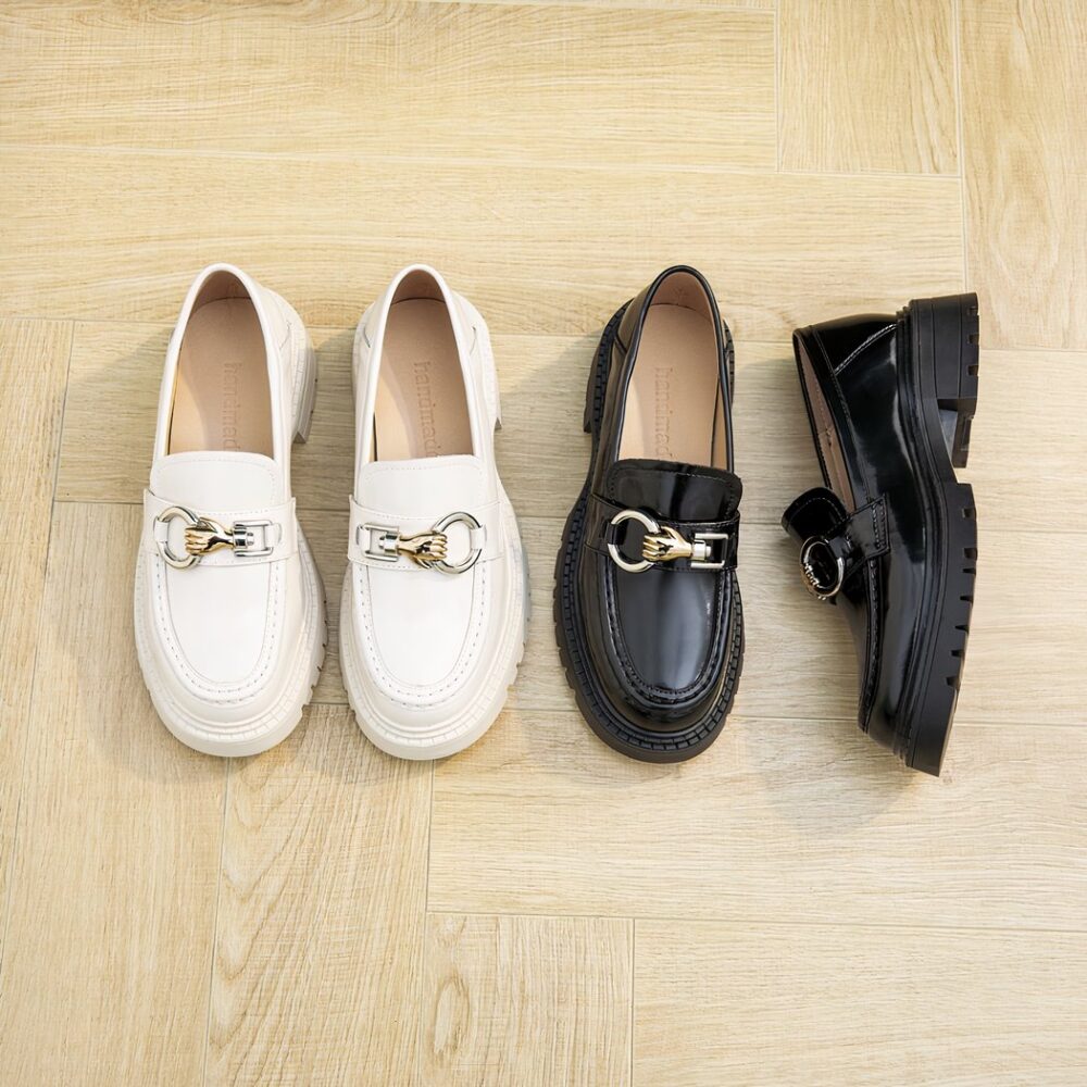 Photo of two pairs of beige and black moccasins on a pink background