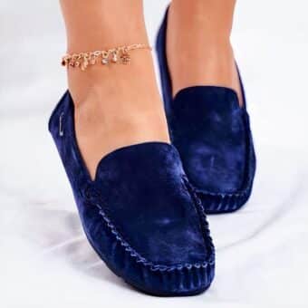 Woman wearing blue loafers highlighted by an ankle bracelet