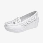 A white loafer in profile, with a wedge sole and holes on the front and sides.